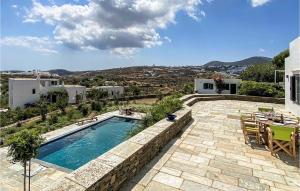 a villa with a swimming pool and a table and chairs at Stunning Home In Sifnos With House Sea View in Sifnos
