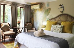 Wildebraam Berry Estate في سويلندام: غرفة نوم مع سرير مع دمية الدب يجلس عليها