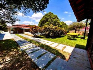 einen Garten mit einem Gehweg vor einem Haus in der Unterkunft Chácara do Zizi in Elias Fausto