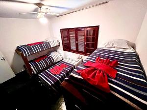 ein Schlafzimmer mit einem gestreiften Bett mit Schleifen darauf in der Unterkunft Chácara do Zizi in Elias Fausto