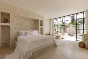 ケロボカンにあるLuxe & Unique honeymoon Bocami Suites- 1 by OriVistaの大きなベッドと大きな窓のある寝室