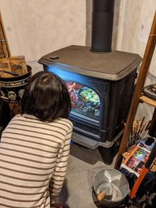 a person sitting in front of a stove at オーシャンビューゲストハウスEat&Stay ROMEY in Shizuoka