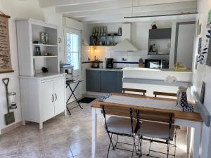 kuchnia ze stołem i krzesłami w pokoju w obiekcie Charmante Maison avec Jardin, Terrasse et Parking - Animaux Acceptés - FR-1-418-196 w mieście Le Palais