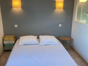 łóżko z 2 poduszkami w sypialni z 2 światłami w obiekcie Charmante Maison avec Jardin, Terrasse et Parking - Animaux Acceptés - FR-1-418-196 w mieście Le Palais