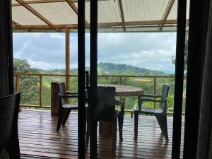 a table and chairs on a deck with a view at Meraki in Pereira