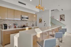 a kitchen with a large white counter and chairs at Breathtaking Luxury Villa Architectural Jewel in Palm Springs