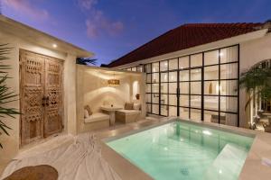 eine Villa mit Swimmingpool und ein Haus in der Unterkunft Luxe & Unique honeymoon Bocami Suites- 2 by OriVista in Kerobokan