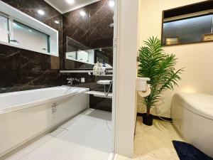 a bathroom with a tub and a toilet and a sink at Japanese style hotel Morigen in Kyotango