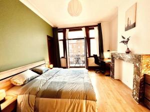 1 dormitorio con 1 cama grande y chimenea en Cozy, comfortable apt, well located - EU ULB VUB, en Bruselas