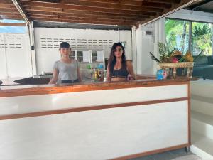 two women standing behind a counter in a kitchen at Haad Chao Phao Resort in Haad Chao Phao