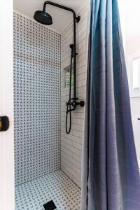 La salle de bains est pourvue d'une douche avec un rideau de douche bleu. dans l'établissement Cozy Cabin in a rural setting (#10) In Temple, NH, 