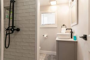 baño blanco con ducha y lavamanos en Cozy Cabin in a rural setting (#10) In Temple, NH, 