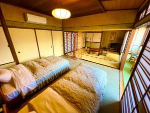 Habitación con vistas a un dormitorio con cama y sala de estar. en Japanese style hotel Morigen, en Kyotango