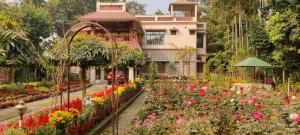 un jardín de flores frente a un edificio en Rater Tara Diner Rabi Resort, en Santiniketan