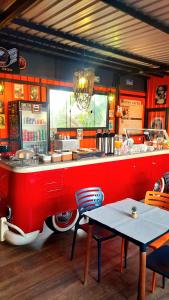 a restaurant with a red counter with a table and chairs at Hotel Bonito Motobox - HOTEL CONTAINER in Bonito