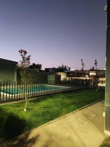 einen Zaun vor einem Hof mit einem Baum in der Unterkunft Arriendo hermoso departamento in Santiago