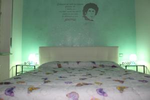 a bedroom with a large bed with a poster on the wall at Rooms Of Love in Pavia