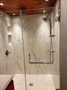 La salle de bains est pourvue d'une douche avec une porte en verre. dans l'établissement Authentic 4 bedroom house !, à Roatán