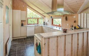 a large kitchen with wooden cabinets and a large island at Lovely Home In Samsø With Wifi in Onsbjerg