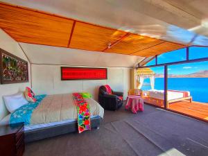 una camera da letto su una barca con un letto e un balcone di Uros Qhantany Lodge a Puno