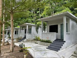 a house with a green door and some trees at Pangkor Nature View House in Pangkor