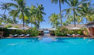 uma piscina num resort com palmeiras em Bayview - The Beach Resort em Ngapali