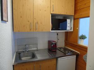 uma pequena cozinha com um lavatório e um micro-ondas em Studio Valfréjus, 1 pièce, 3 personnes - FR-1-561-52 em Valfréjus