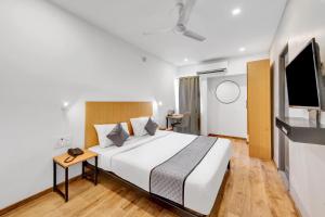 a hotel room with a bed and a television at Upar Hotels Uthandi, ECR in Chennai