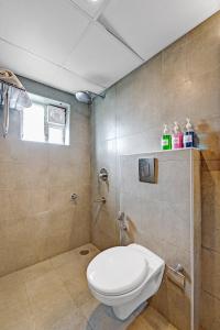 a bathroom with a toilet and a shower at Upar Hotels Uthandi, ECR in Chennai