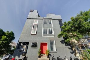 a tall gray building with a red door at Upar Hotels Uthandi, ECR in Chennai