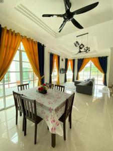 uma sala de jantar com uma mesa e uma ventoinha de tecto em homestay kubang ikan chendering 5minit ke pantai em Kuala Terengganu