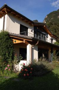 ein weißes Haus mit einem Balkon und einigen Blumen in der Unterkunft B&B Il Vigneto in Melano