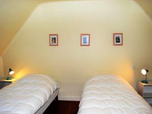 Duas camas num quarto com fotografias na parede em Maison Trébeurden, 3 pièces, 5 personnes - FR-1-368-71 em Trébeurden