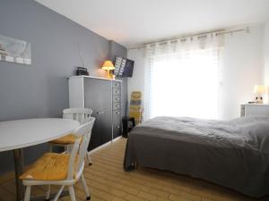 a bedroom with a bed and a table and chairs at Studio Balaruc-les-Bains, 1 pièce, 2 personnes - FR-1-553-100 in Balaruc-les-Bains