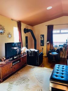 Una sala de estar con un televisor de pantalla plana y un sofá. en The Tuwanek Bed and Breakfast, en Sechelt