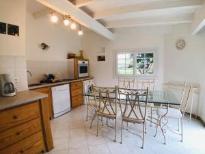 una cocina con mesa de cristal y sillas. en Maison Corbara, 4 pièces, 7 personnes - FR-1-63-296 en Corbara