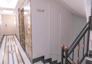 um corredor com uma parede branca e uma escada em Cetin Port Hotel em Istambul