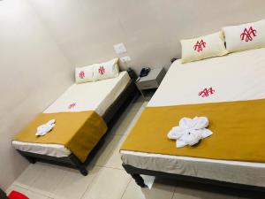 two beds in a small room with flowers on them at MARINA PALACE in Chennai