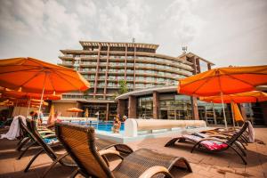 a pool with chairs and umbrellas in front of a hotel at Aquaworld Resort Budapest in Budapest