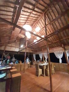 una grande camera con persone sedute ai tavoli in un edificio di Miley Lodging Restobar a New Busuanga