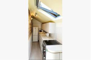 a kitchen with white appliances and a skylight at The Annexe in Radstock