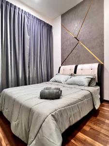 1 dormitorio con 1 cama grande y cabecero gris en The D Carlton HomeStay 2BR, en Masai