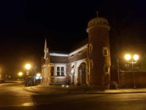 a building with a tower on a street at night at Ferienwohnung Leuchtturm 29a in Guben