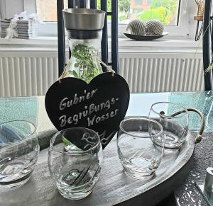 a tray with glasses and a bottle on a table at Ferienwohnung Leuchtturm 29a in Guben