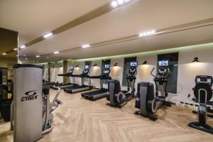 a gym with a row of treadmills and machines at MUU Bangkok Hotel in Bangkok