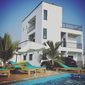a building with a swimming pool next to a hotel at FIRST RESIDENCE KRIBI in Kribi