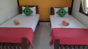 two beds in a room with red and white sheets at Wild View Stay in Habarana