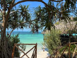 una playa con palmeras y vistas al océano en Z-Lodge Zanzibar, en Kiwengwa