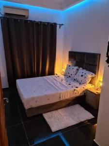 Bett in einem Zimmer mit einem schwarzen Vorhang in der Unterkunft FIRST RESIDENCE KRIBI in Kribi