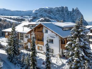 un lodge de esquí con nieve en las montañas en Hotel Bellavista en Alpe di Siusi